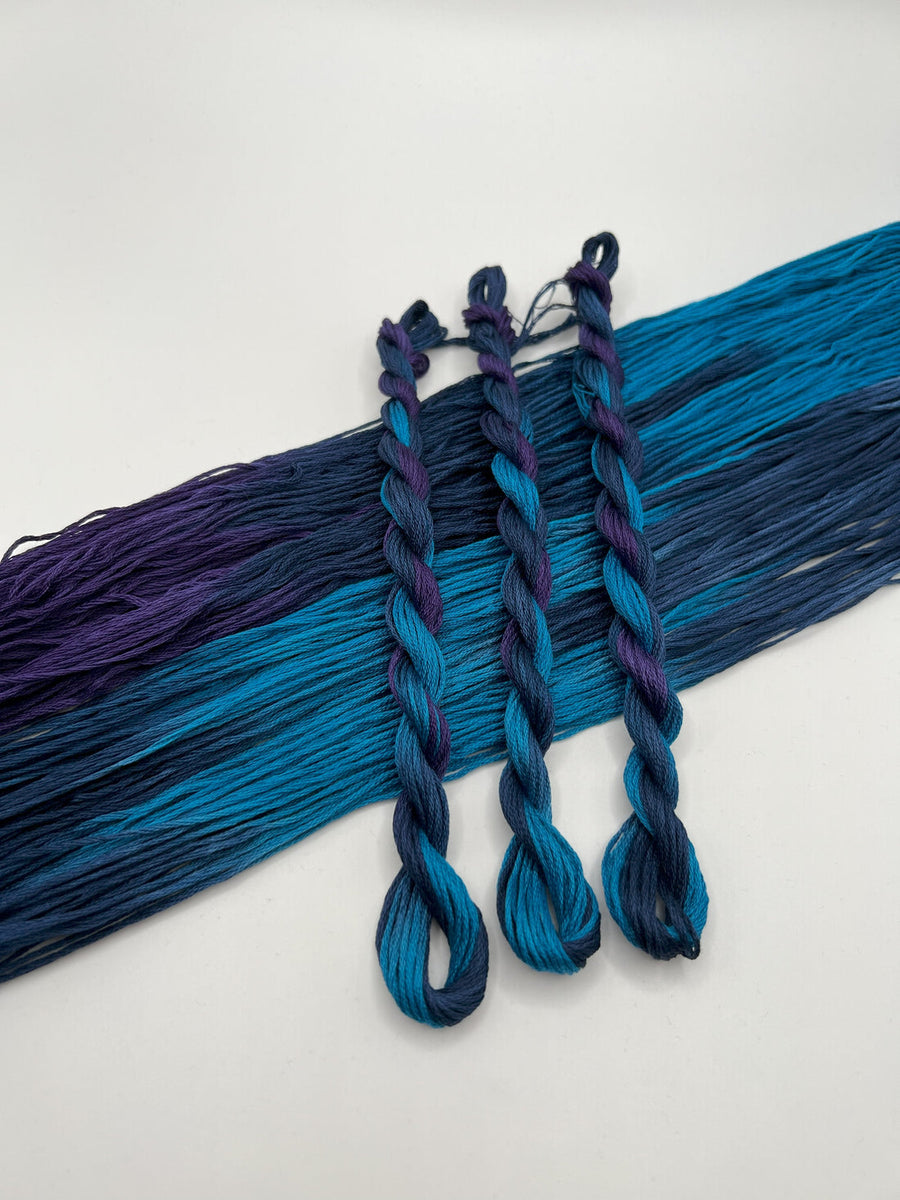 Blue and purple braided hair extensions on a white background