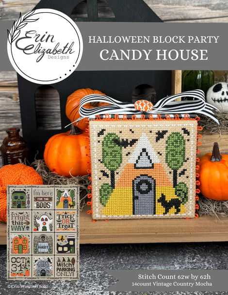 Halloween-themed cross-stitch pattern with pumpkins and a candy house design on a wooden surface.