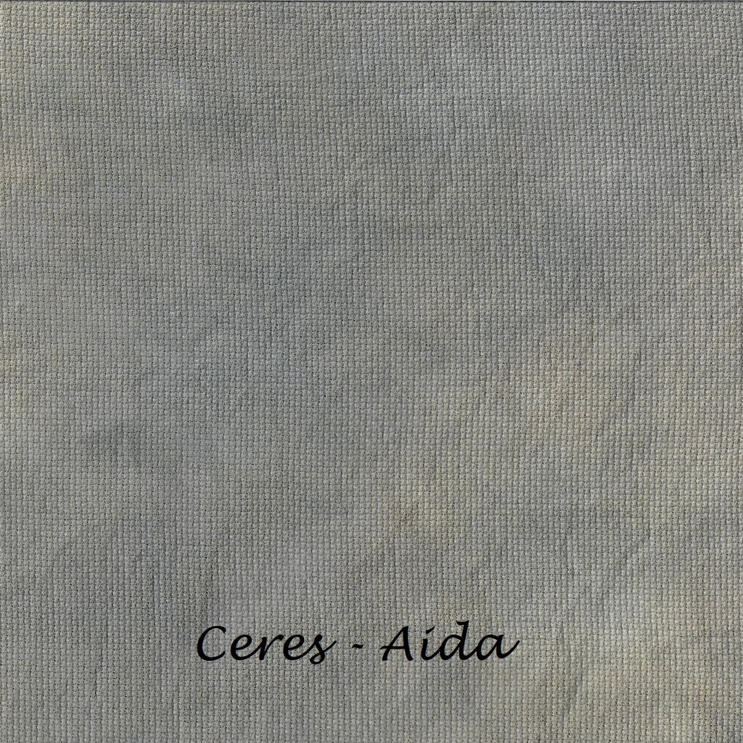 A close-up of a textured gray fabric or material swatch with the text 'Ceres - Aida' printed in black at the bottom center.
