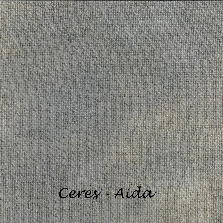 A close-up of a textured gray fabric or material swatch with the text 'Ceres - Aida' printed in black at the bottom center.