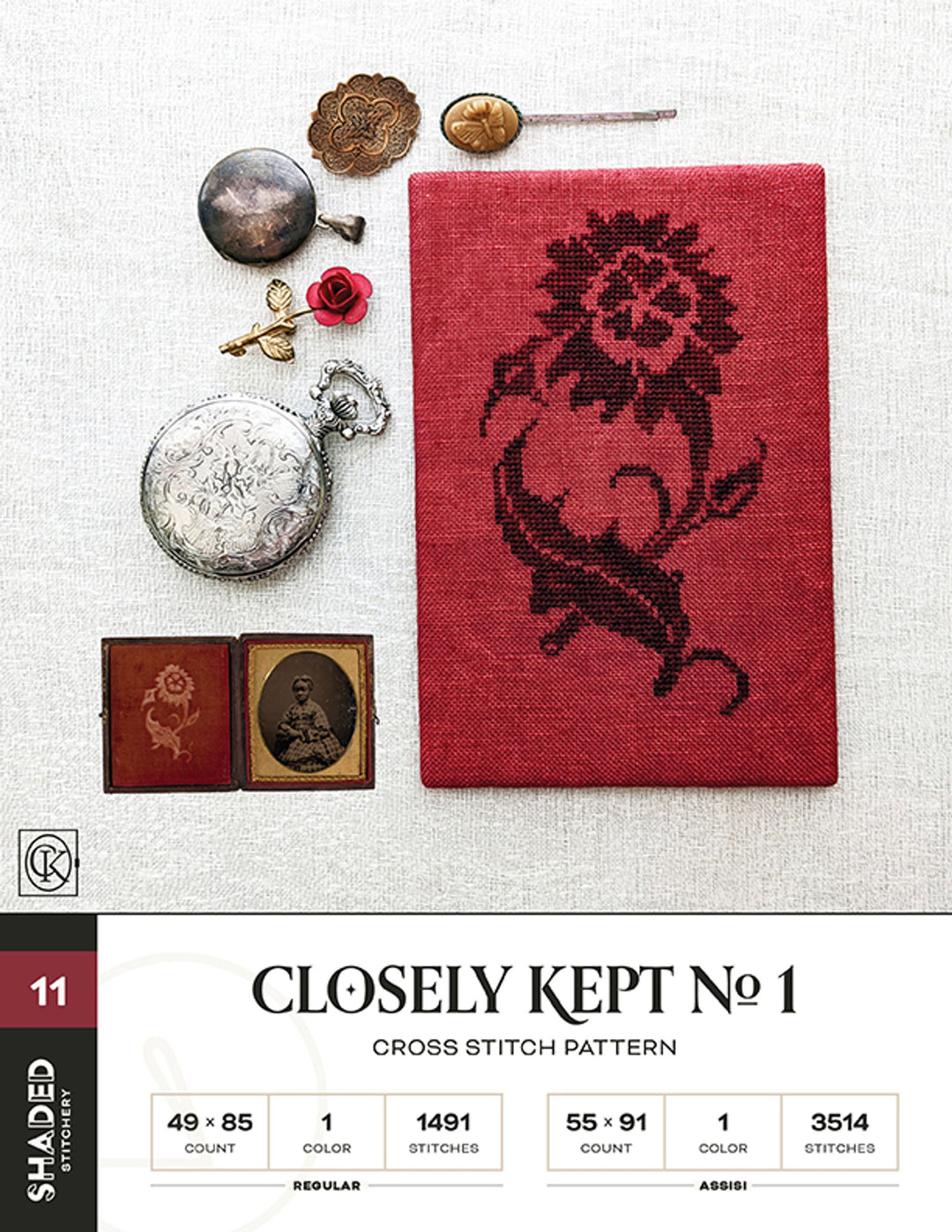 Cross stitch pattern with floral design on red fabric, surrounded by vintage items on a white background.
