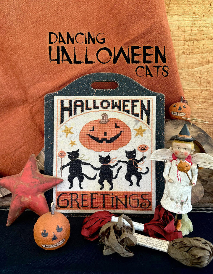 Halloween-themed decorative item with black cats, pumpkin, and text on a rustic background.