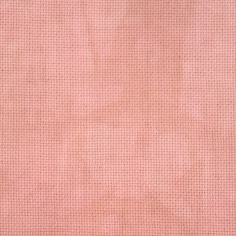 A light coral-ish color aida fabric with brown undertones, close up view showing the texture.