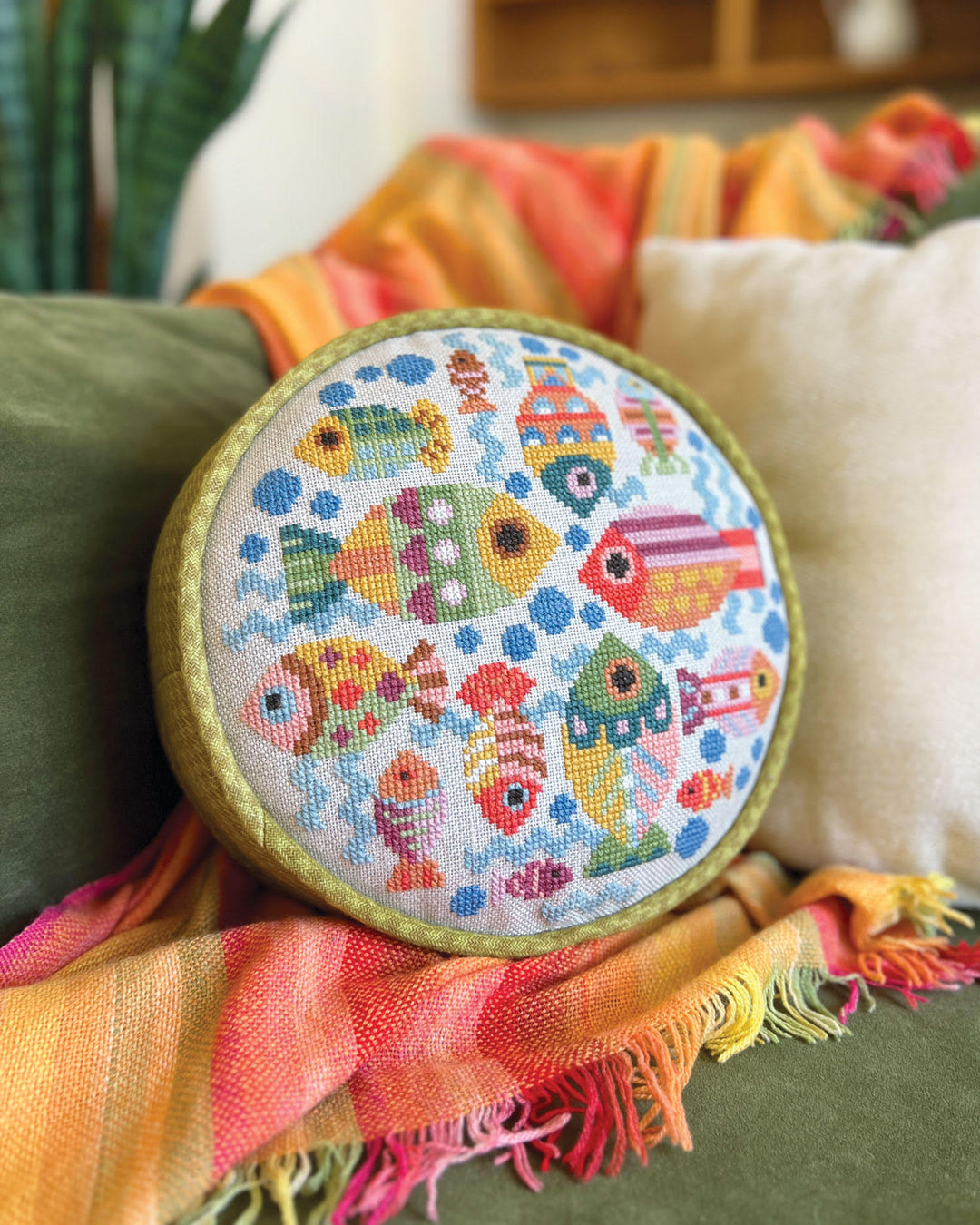 Embroidery hoop with colorful fish pattern on a fabric background