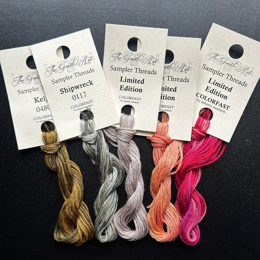 Set of colorful embroidery threads with labels on a dark background