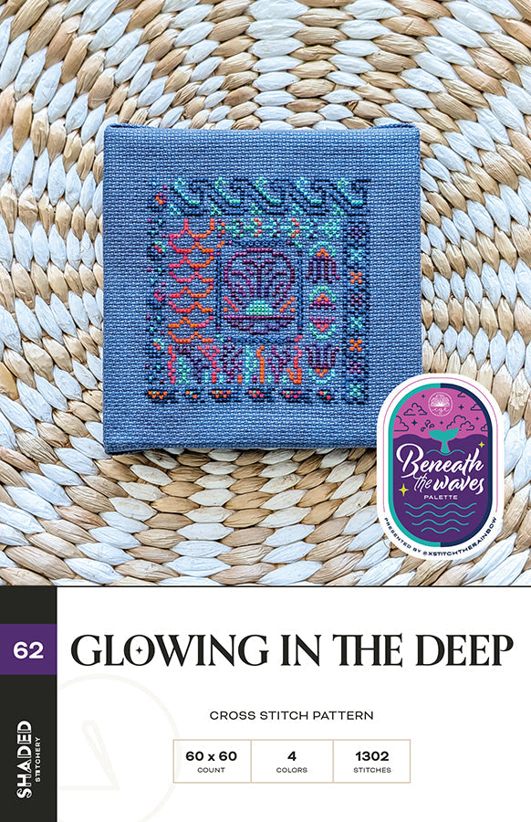 Cross stitch pattern on fabric with 'Beneath the Waves' logo on a woven background