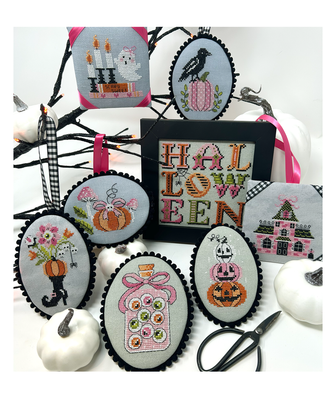 Halloween-themed cross-stitched ornaments and a framed 'Halloween' sign on a white background.
