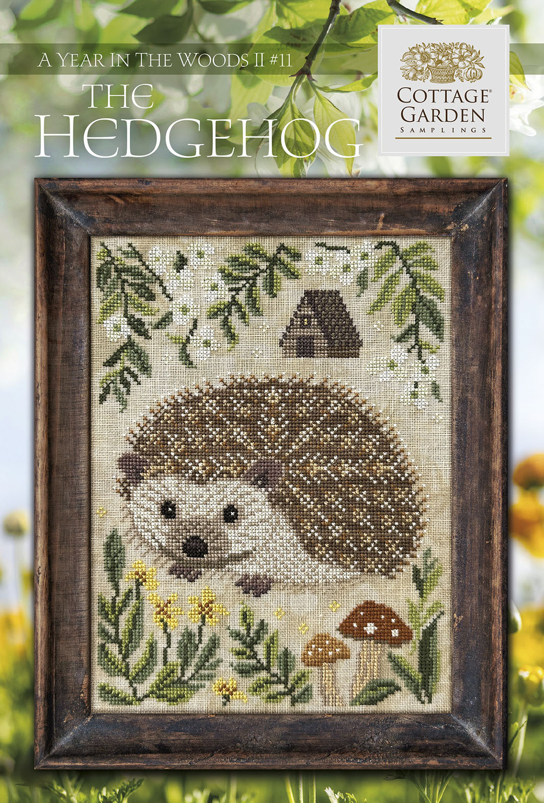 Cross-stitched hedgehog design in a wooden frame with a Cottage Garden logo.