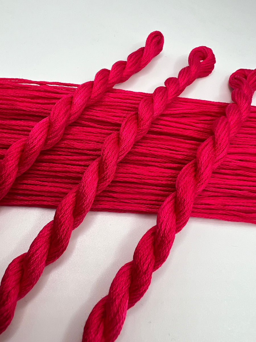 Red yarn strands on a white background