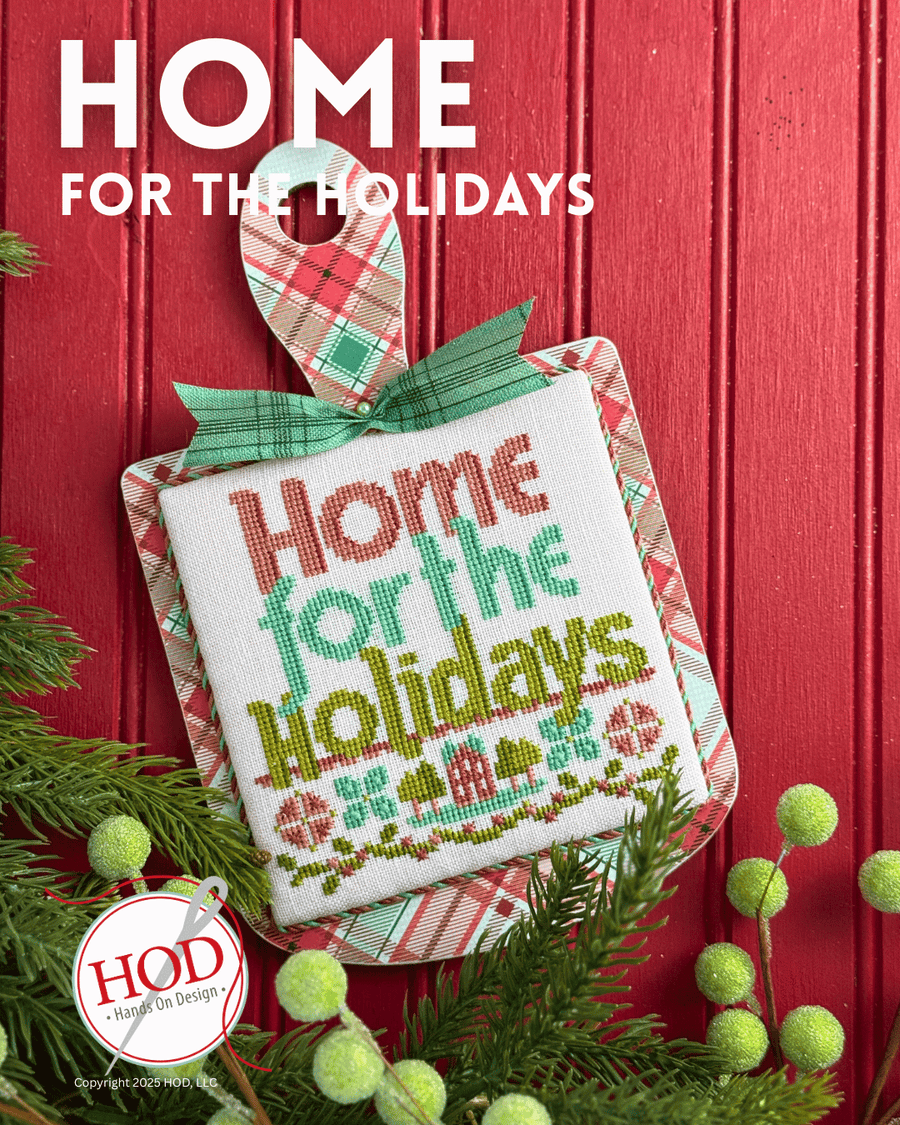 Decorative cross-stitch piece with 'Home for the Holidays' text on a red background