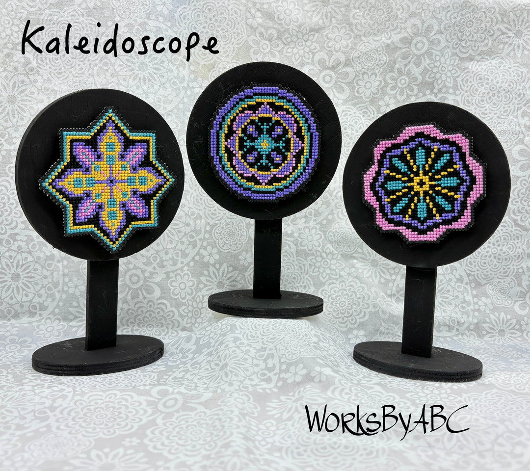 Three kaleidoscope designs on black stands with 'Kaleidoscope WorksByABC' branding.