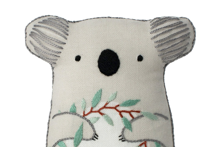 Stuffed koala toy with leaf design on a white background