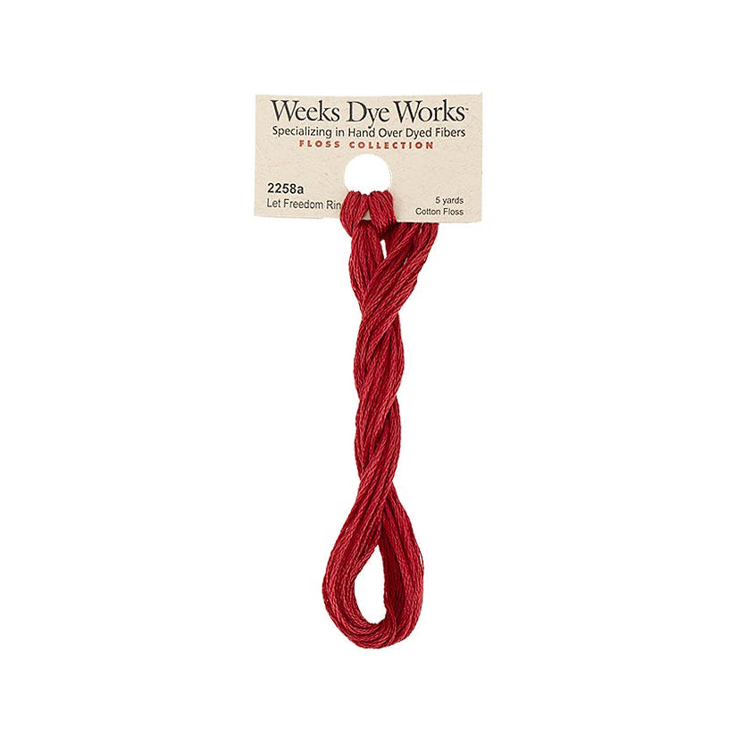 A single skein of Weeks Dye Works led freedom ring red embroidery thread on a white background with its paper label visible at the top.
