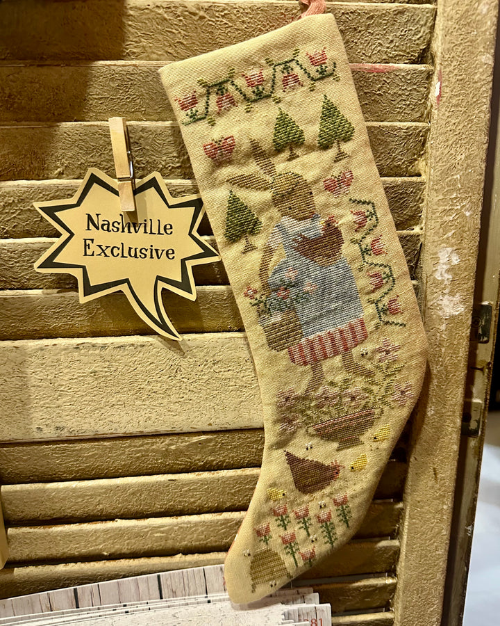 Decorative stocking with a 'Nashville Exclusive' tag on a wooden surface
