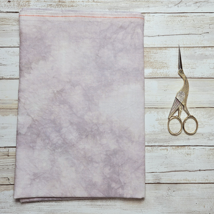 medusa's gaze lapin loops cross stitch linen light purple fabric displayed with pair of stork embroidery scissors