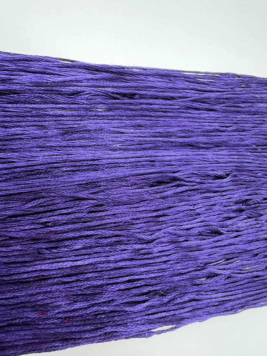 Close-up of purple embroidery floss on a white background