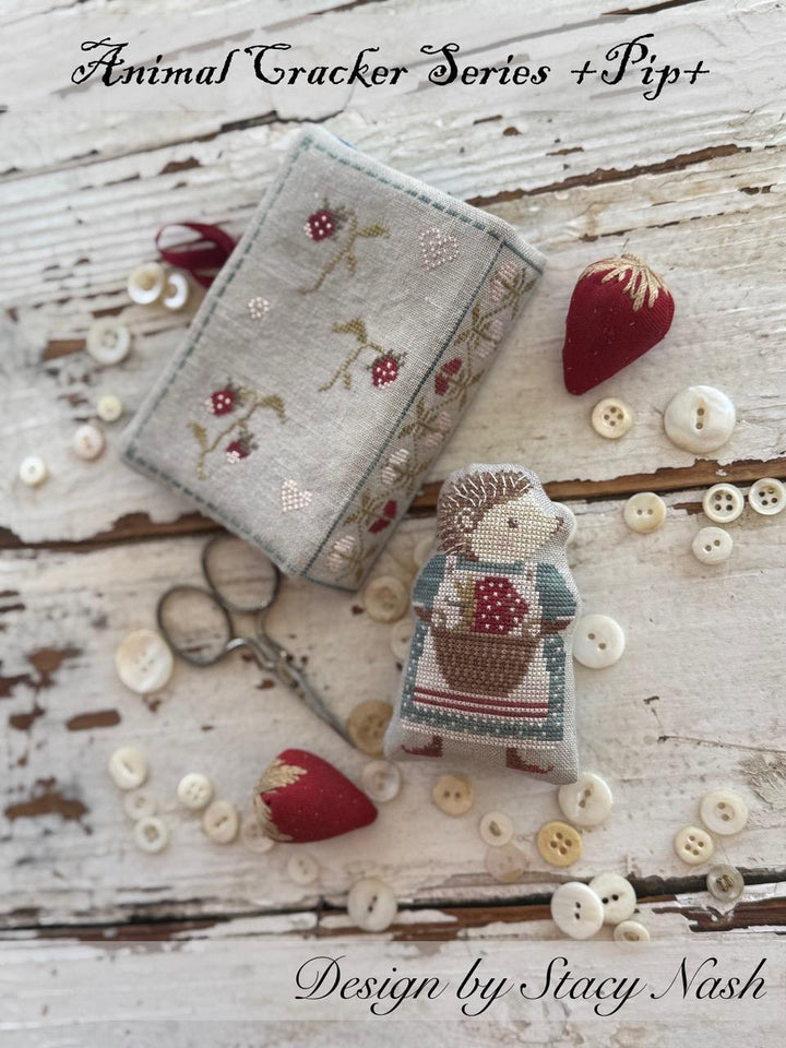 Embroidered fabric box and character with buttons on a wooden surface, featuring 'Animal Cracker Series + Pip' design by Stacy Nash.