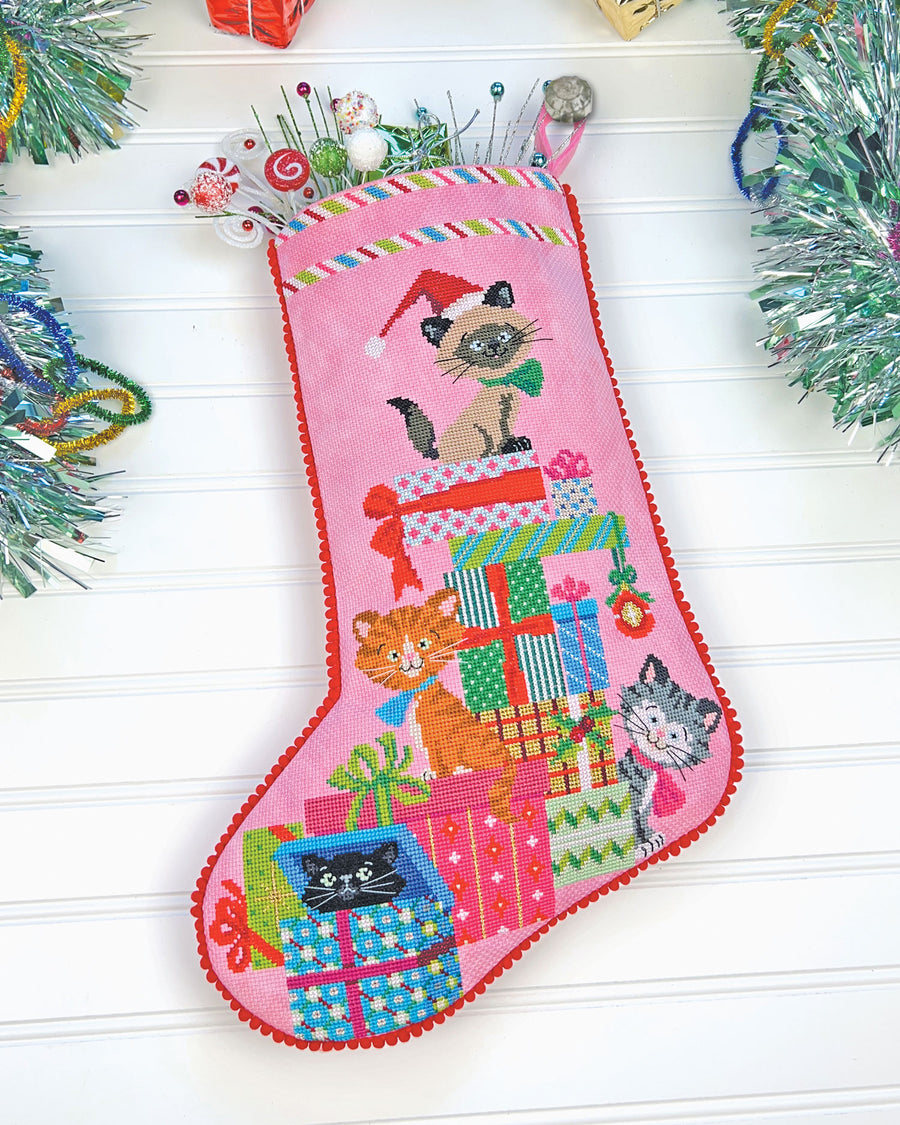 Pink Christmas stocking with cat designs on a white background
