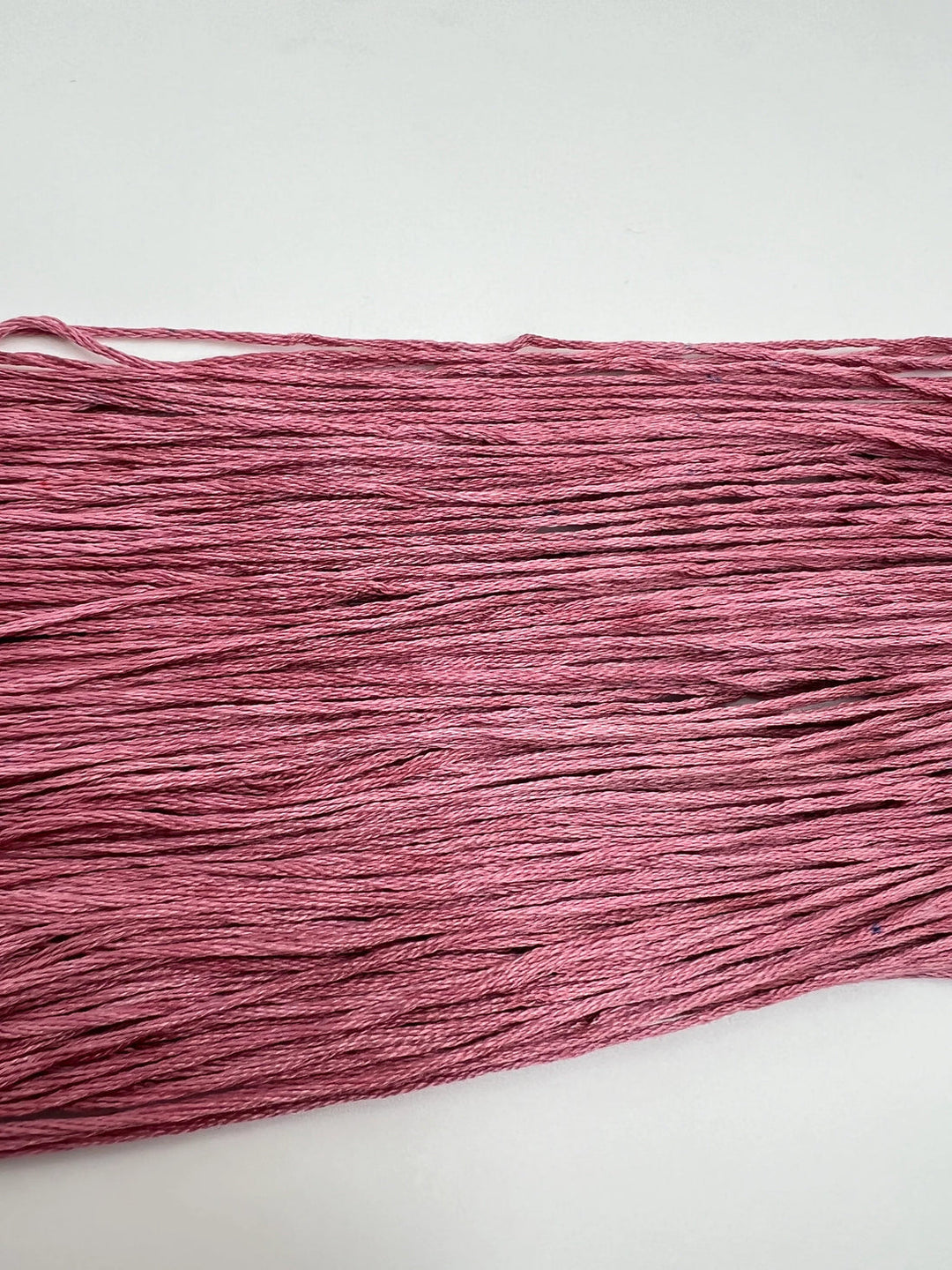 Pink thread on a white background