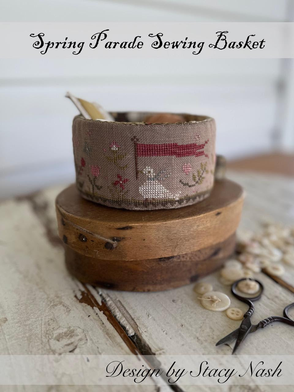 Sewing basket with decorative lid and sewing tools on a wooden surface