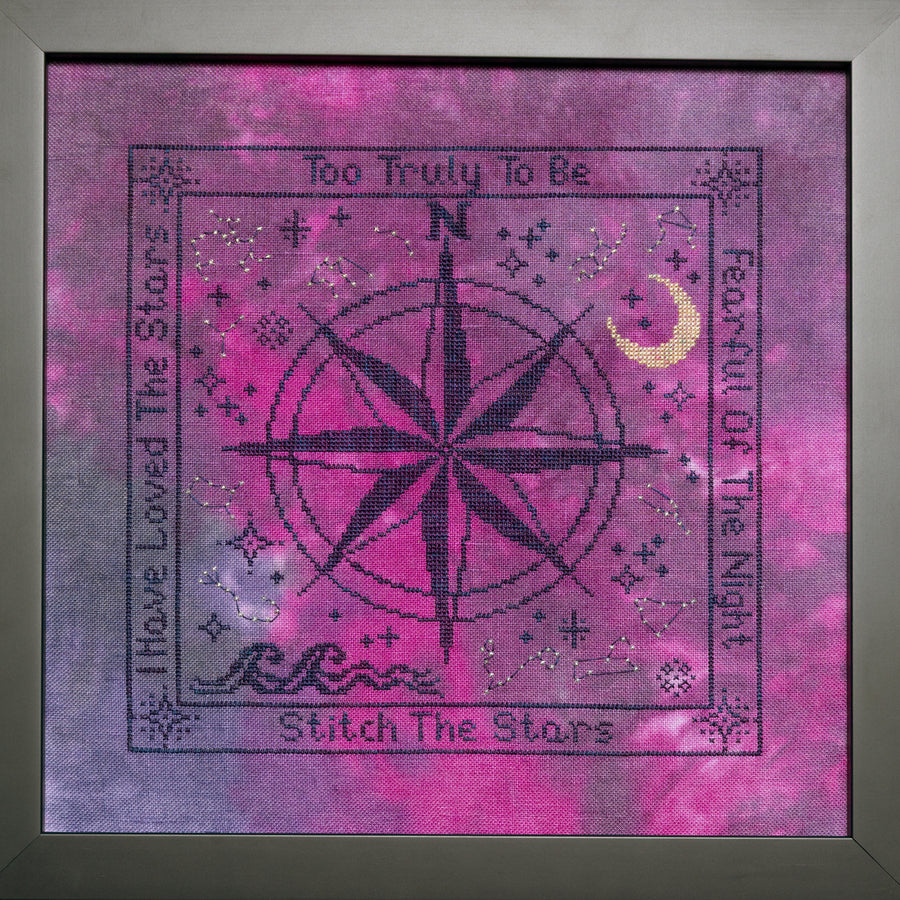 Cross-stitched design with compass rose and text on a pink and purple background