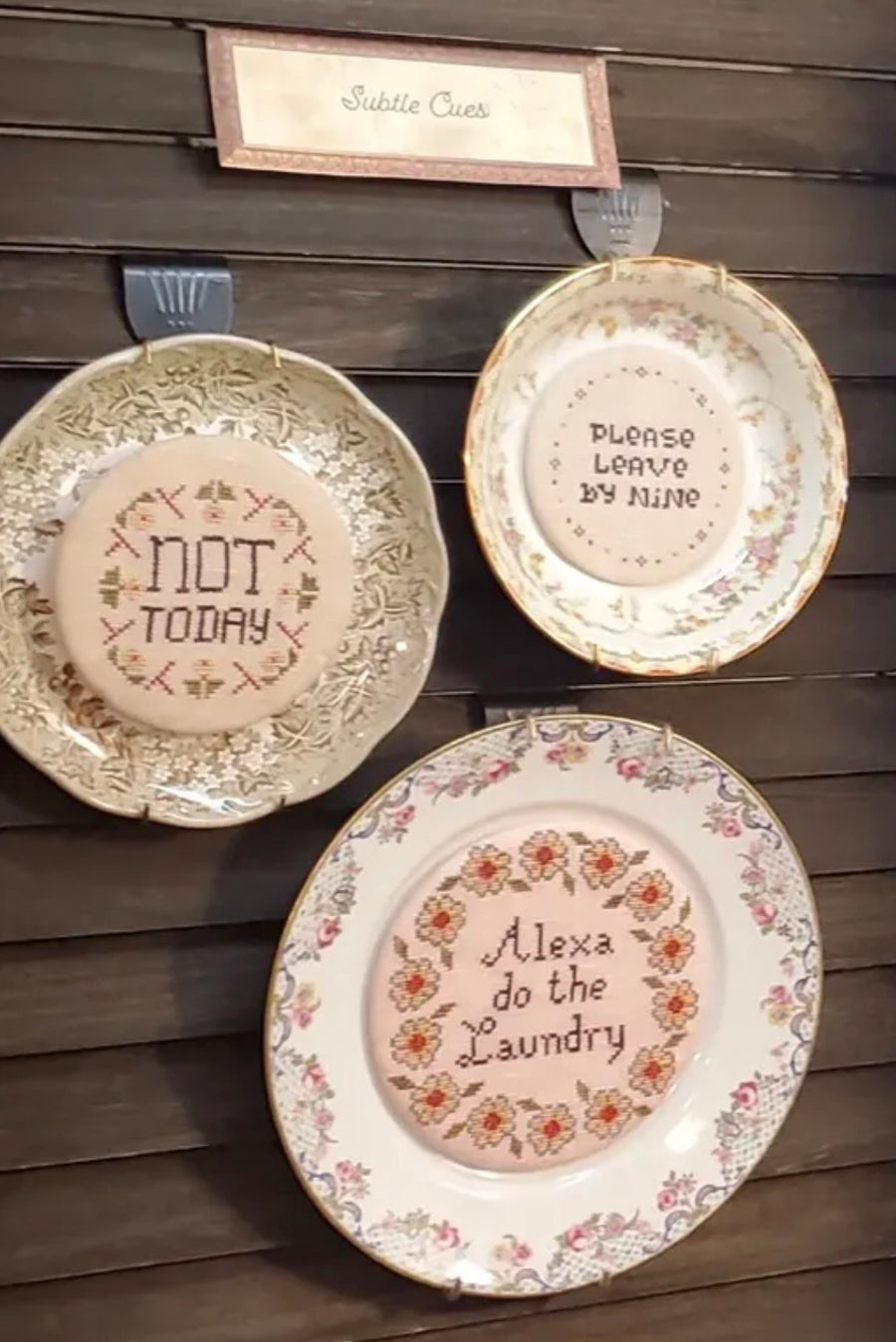 Decorative plates with humorous sayings on a wooden wall