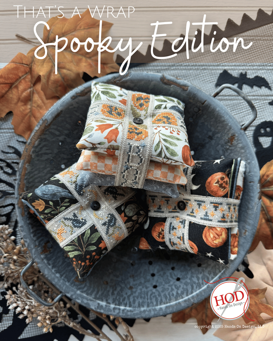 Decorative pillows with Halloween patterns in a metal basket, surrounded by autumn leaves and pumpkins.