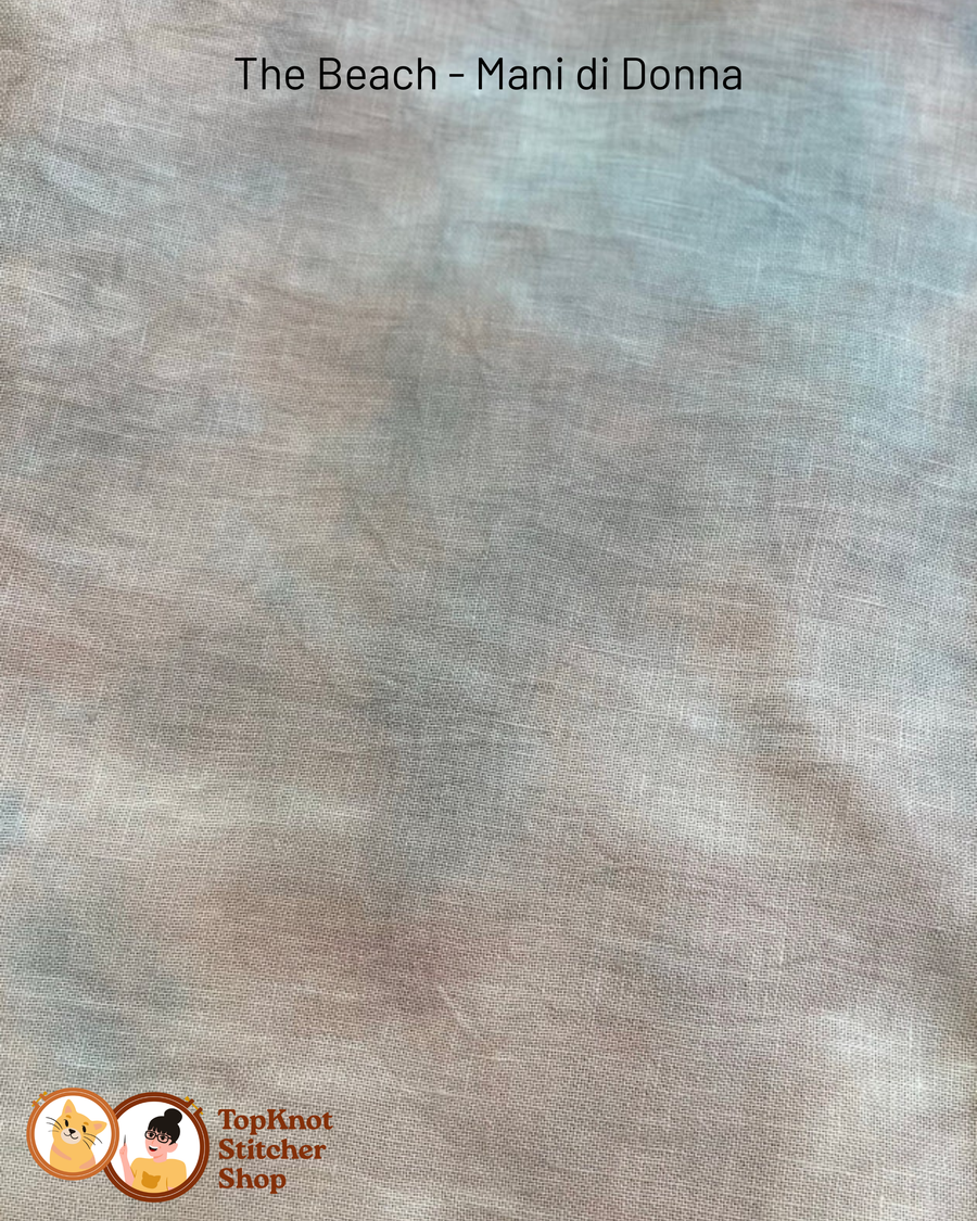 Textured light brown and blue grey fabric swatch with 'The Beach - Mani di Donna' branding and 'TopKnot Stitcher Shop' logo.