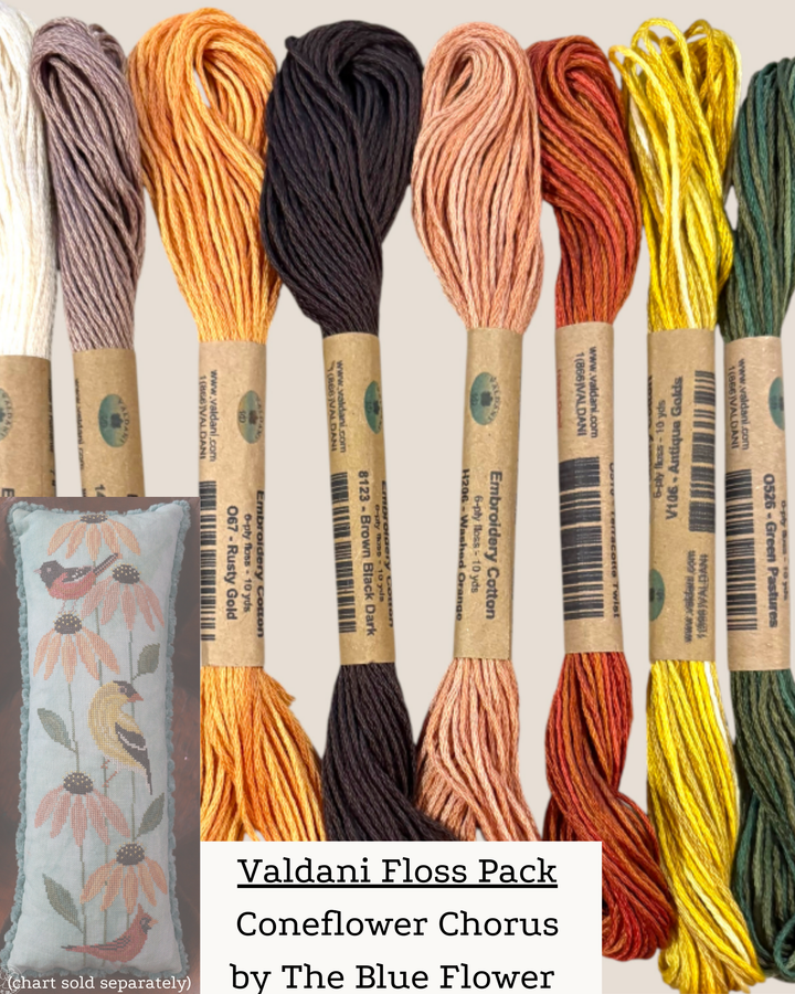 Collection of Valdani embroidery floss skeins in various colors with a sample project in the background.