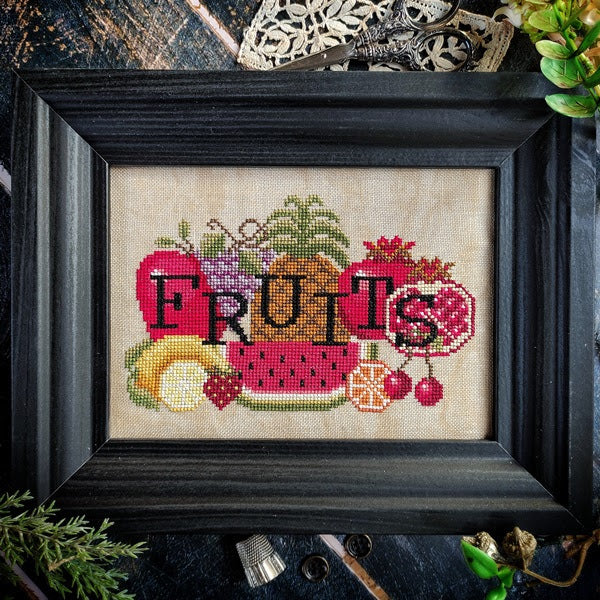 cross stitch of serveral fruits including lemon watermelon pineapple grapes pomegranate and text overlaid reading 'fruits'