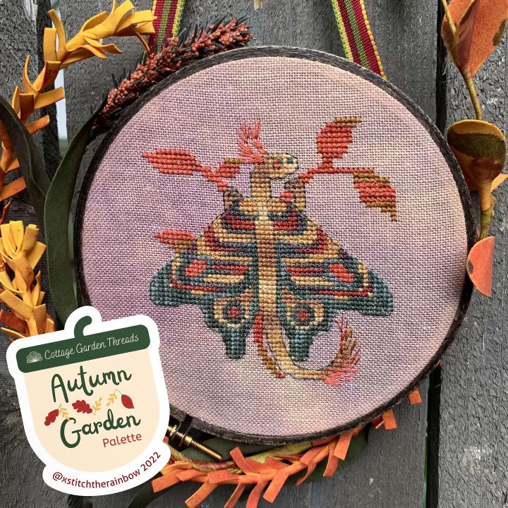 Embroidery hoop with autumn-themed cross-stitch design on a matching fabric background, featuring the label 'Cottage Garden Threads Autumn Garden Palette'.