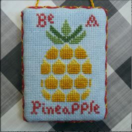 A cross-stitch pattern depicting a blue background with a large yellow pineapple in the center and the text 'BE A PINEAPPLE' below it.