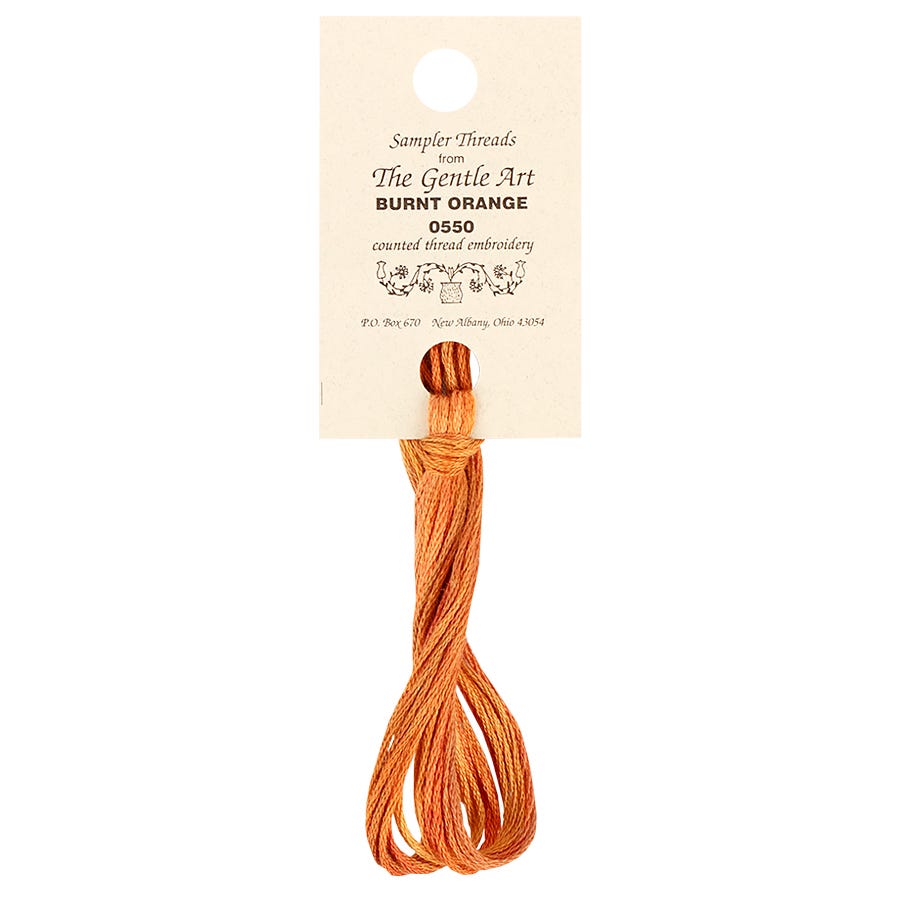 A skein of burnt orange embroidery floss labeled 'The Gentle Art - Hand-Dyed Embroidery Floss'.