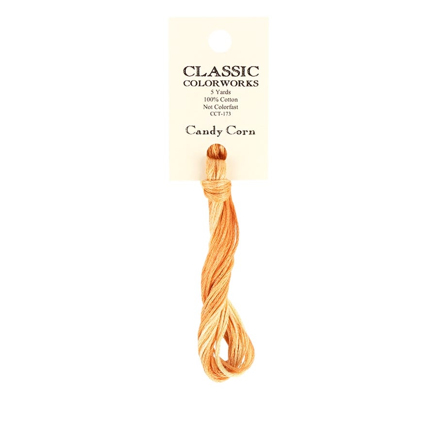 A skein of Classic Colorworks hand-dyed embroidery floss in a shade resembling candy corn, placed on a card with the brand name and product name visible.