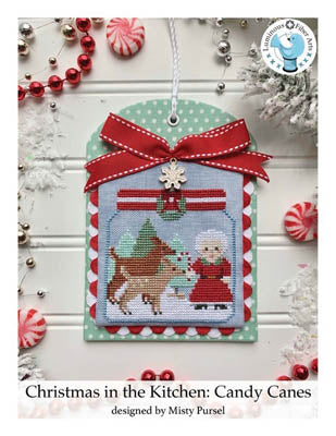 A festive Christmas-themed cross stitch kit depicting candy canes, Santa, and a reindeer, with a red bow on top and a snow-covered background.