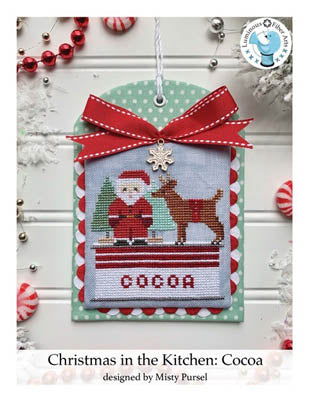 Cross stitch kit depicting Santa Claus and a reindeer with a cocoa theme, framed in a red ribbon.