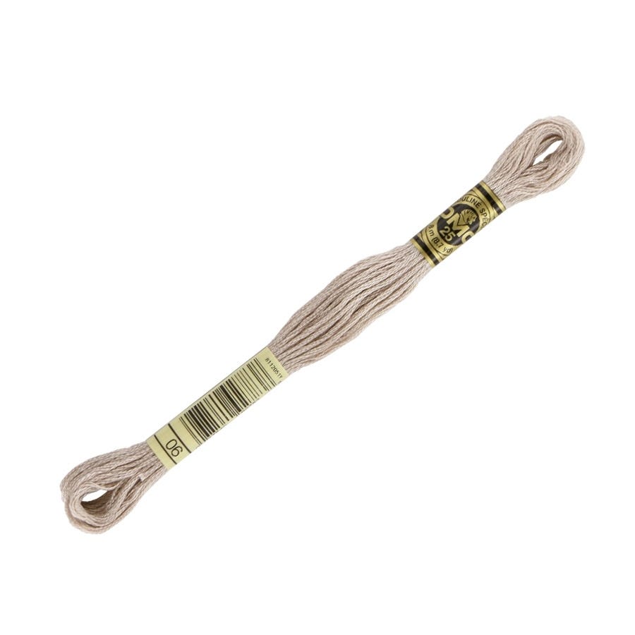 Spool of beige embroidery floss with a label on a white background