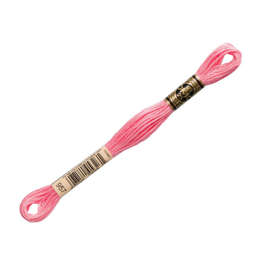 Pink embroidery floss with a gold spool on a white background