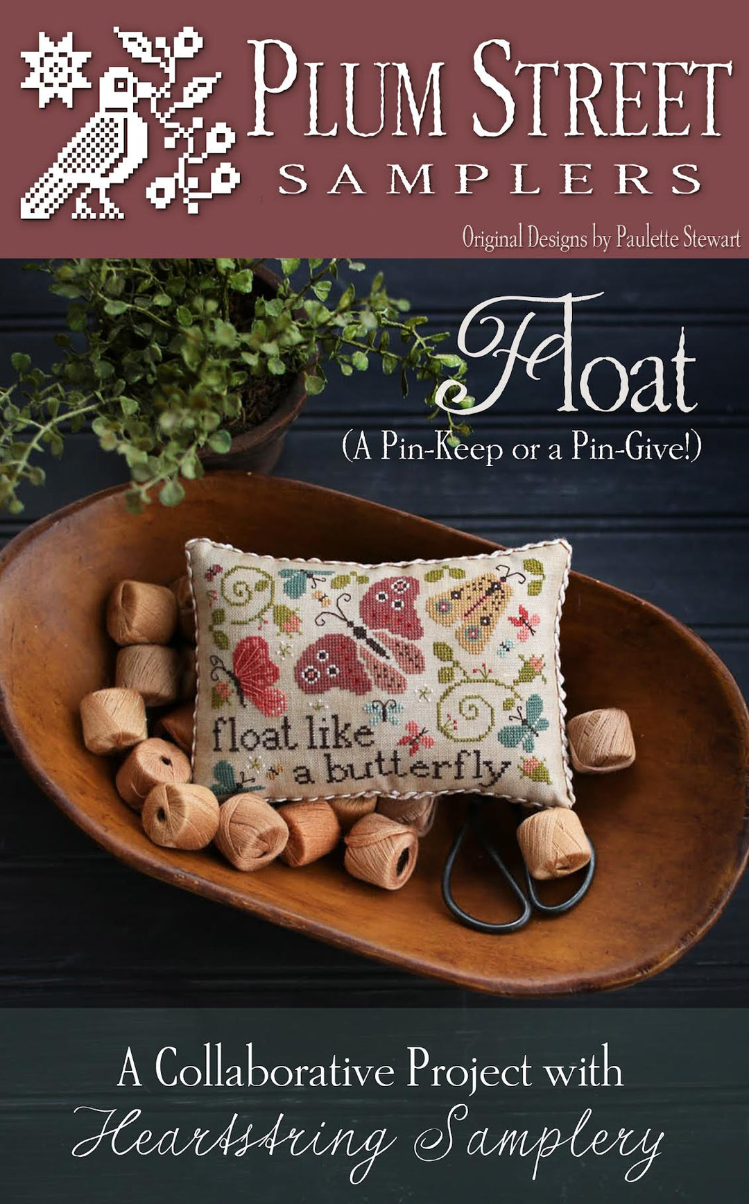 A promotional image featuring a cross-stitch kit called 'Float' by Plum Street Samplers, depicting a butterfly design on a fabric piece, surrounded by small wooden spools of thread and decorative elements.