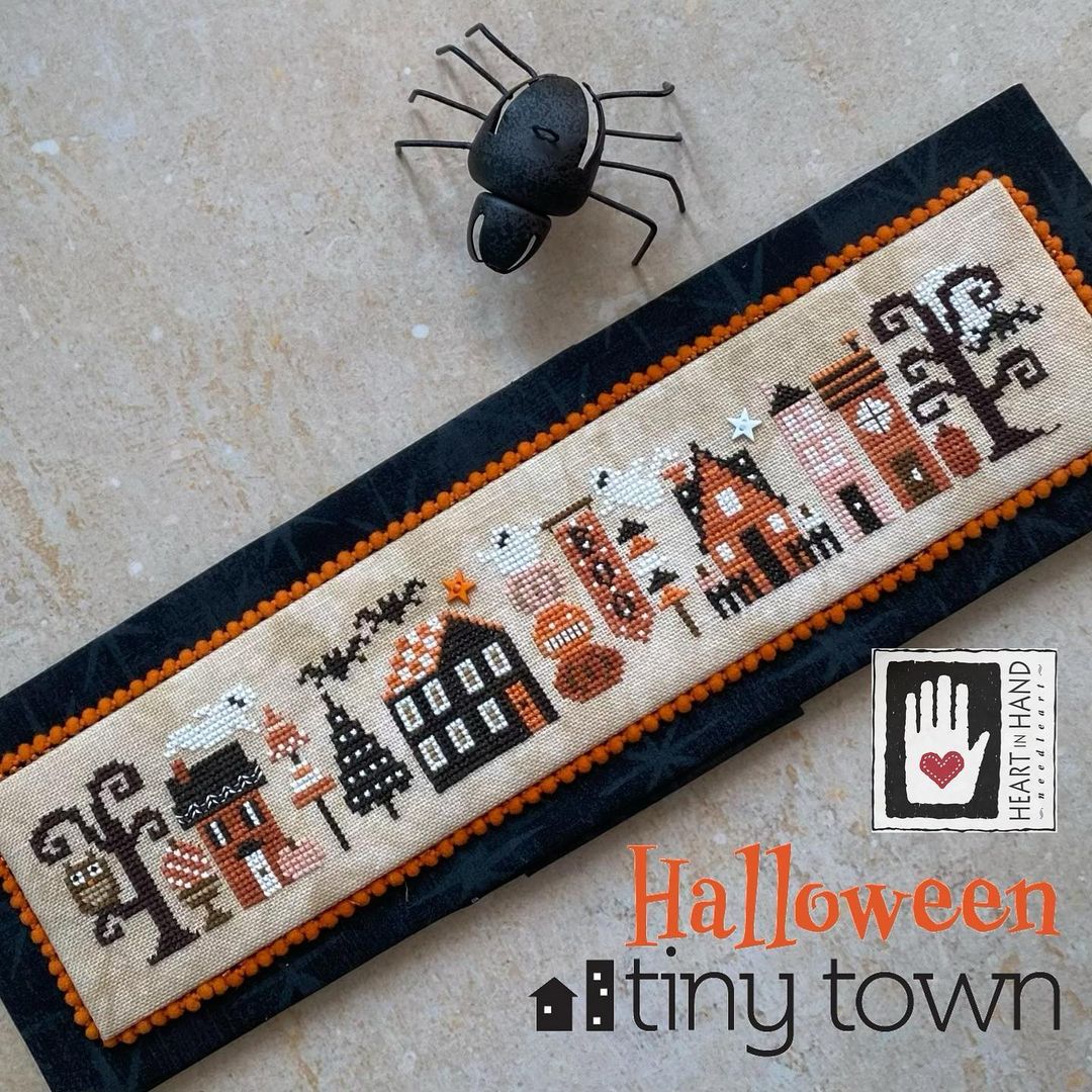 Halloween-themed cross-stitched panel with 'Tiny Town' design on a textured surface.