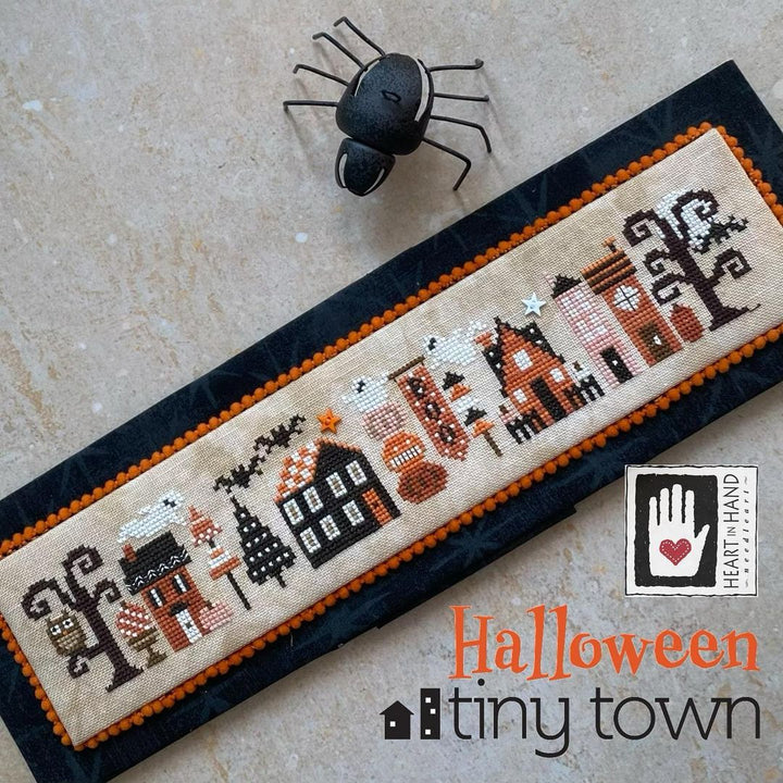 Halloween-themed cross-stitched panel with 'Tiny Town' design on a textured surface.