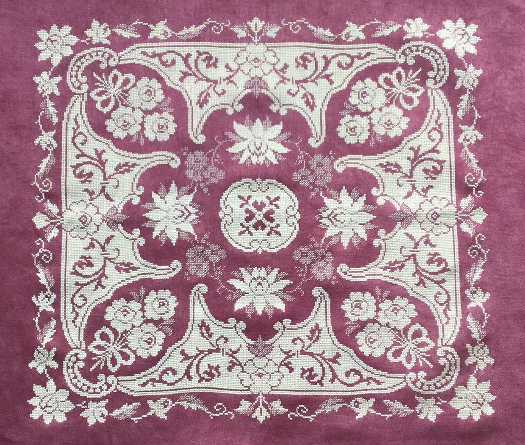cross stitch lace design on pink purple fabric