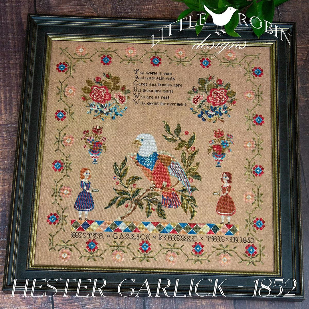 Framed cross-stitched piece with an eagle and floral designs, featuring 'Little Robin Designs' branding.