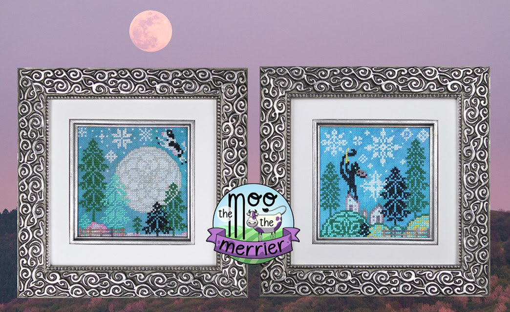 Two framed cross-stitched pieces with winter scenes and a full moon on a purple background.