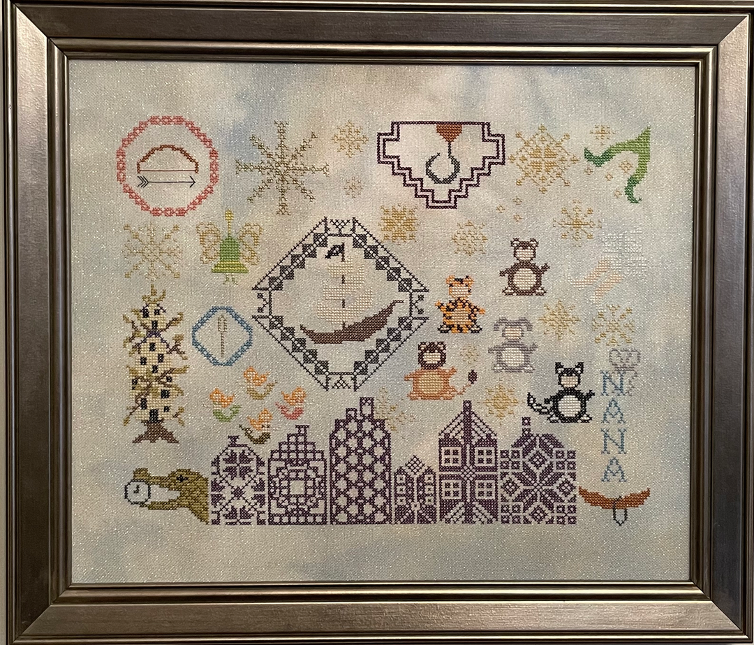 A framed cross-stitch pattern featuring various characters and elements related to the Peter Pan story, stitched with DMC threads and Silvermist Lugana fabric.