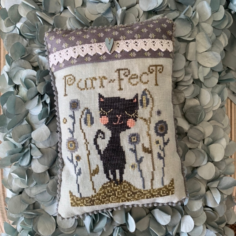 Decorative pillow with a cat illustration and 'Purr-fect' text on a floral background