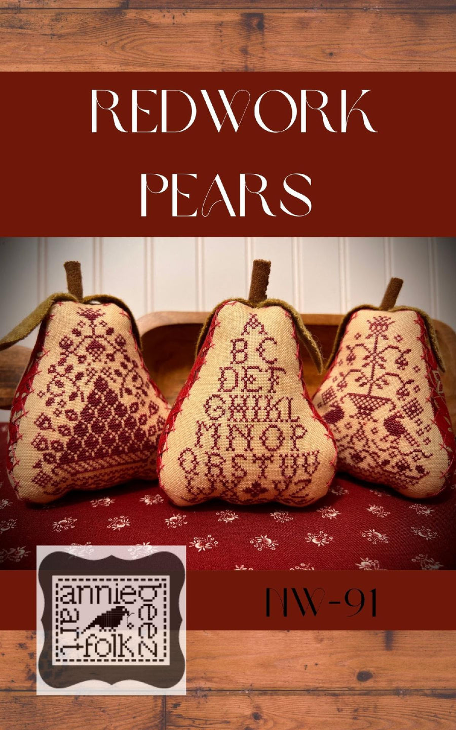 Three needlework pillows shaped like pears with red floral patterns on them, displayed on a wooden surface, with the Annie Beez Folk Art logo and the text 'REDWORK Pears' on the top.
