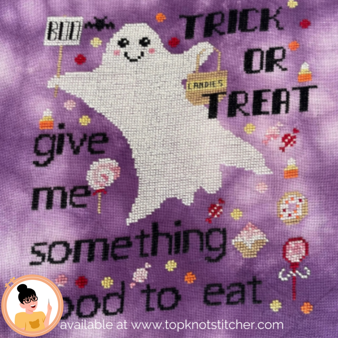 Cross-stitched ghost with Halloween text and candy-themed decorations on a purple background