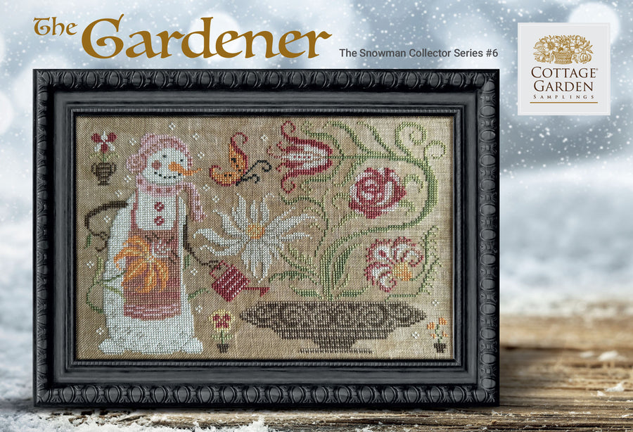 Framed cross-stitch pattern of a snowman and flowers with 'Cottage Garden' branding.
