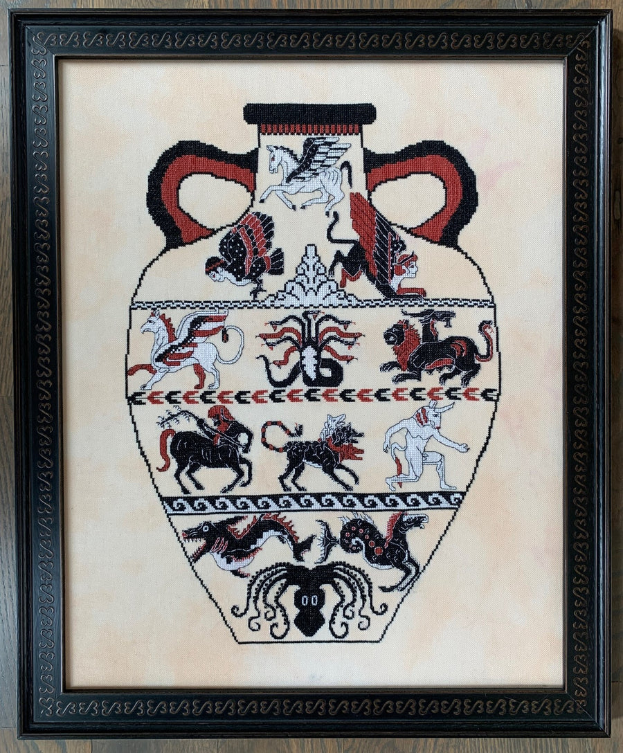 Framed cross-stitched design of an ancient vase with various animals on a beige background